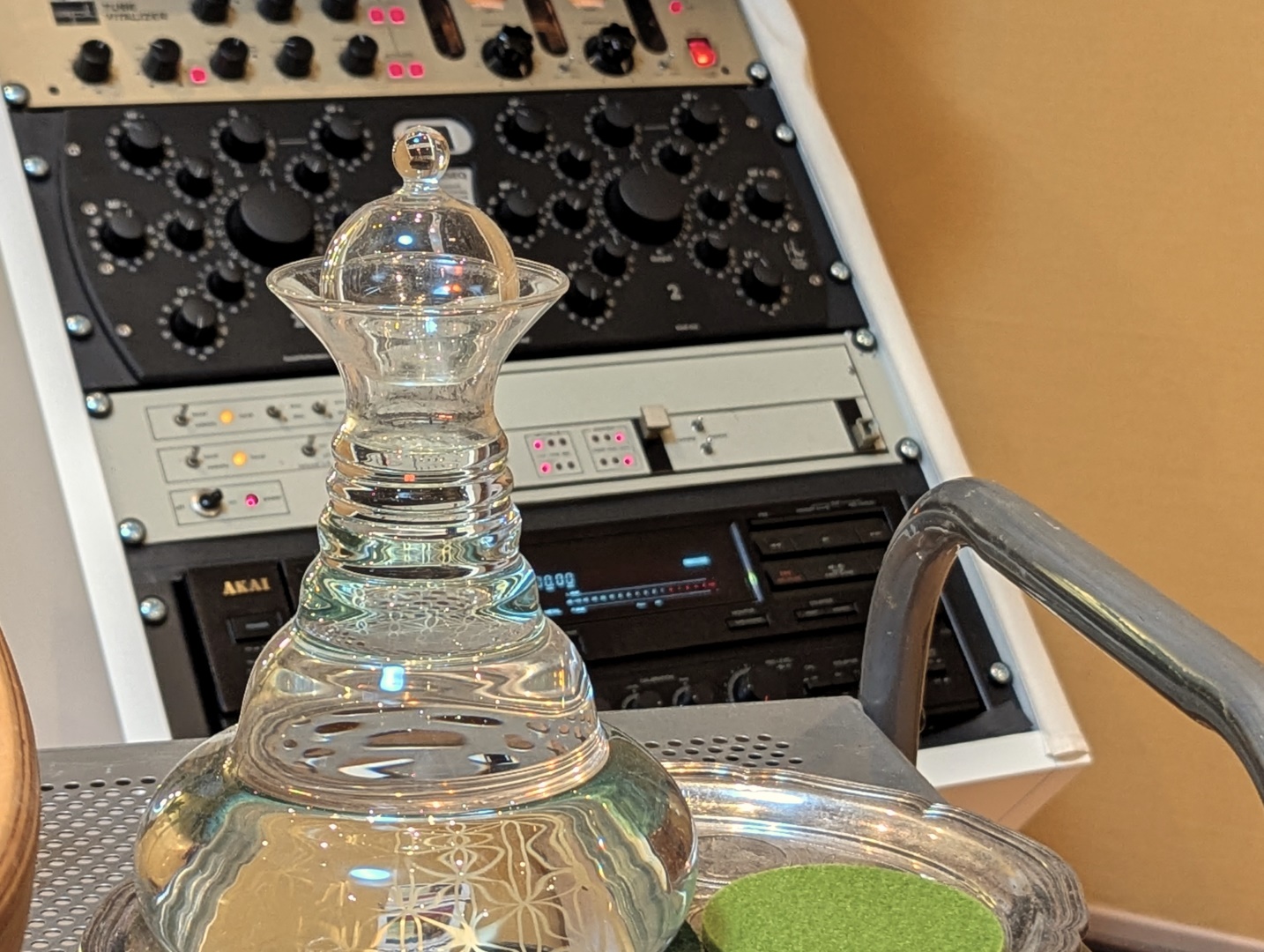 Blick in das Cybele Studio - Kristallglas-Karaffe mit Blume-des-Lebens-Gravur vor dem analogen Mastering-Rack