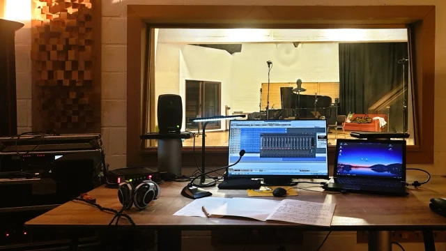 Cybele Studio on the road - Blick aus der Tonregie der DADA Studios (Brüssel, Belgien) in den Aufnahmeraum während der Aufnahme von Kammermusikwerken der belgischen Komponistin Jacqueline Fontyn; im Vordergrund: Sennheiser HD800 Kopfhörer und großer TFT-Bildschirm, der das Merging Pyramix DSD-Aufnahmeprojekt zeigt