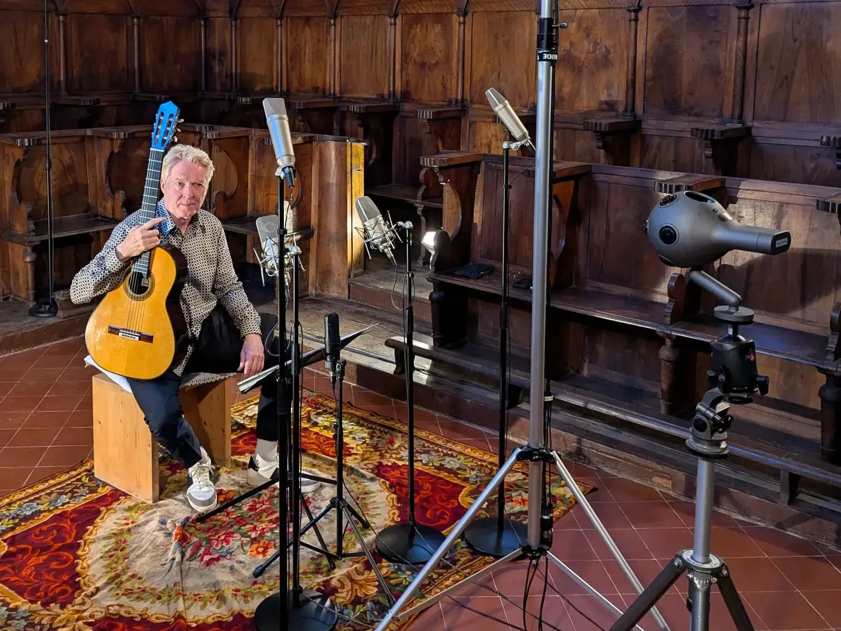Cybele Studio on the road – préparatifs d’enregistrement : Wulfin Lieske et sa guitare Andrea Tacchi dans la chapelle historique d’un monastère près de Florence ; stalles du chœur, caméra VR à 360° et dispositif Dolby Atmos complexe au premier plan