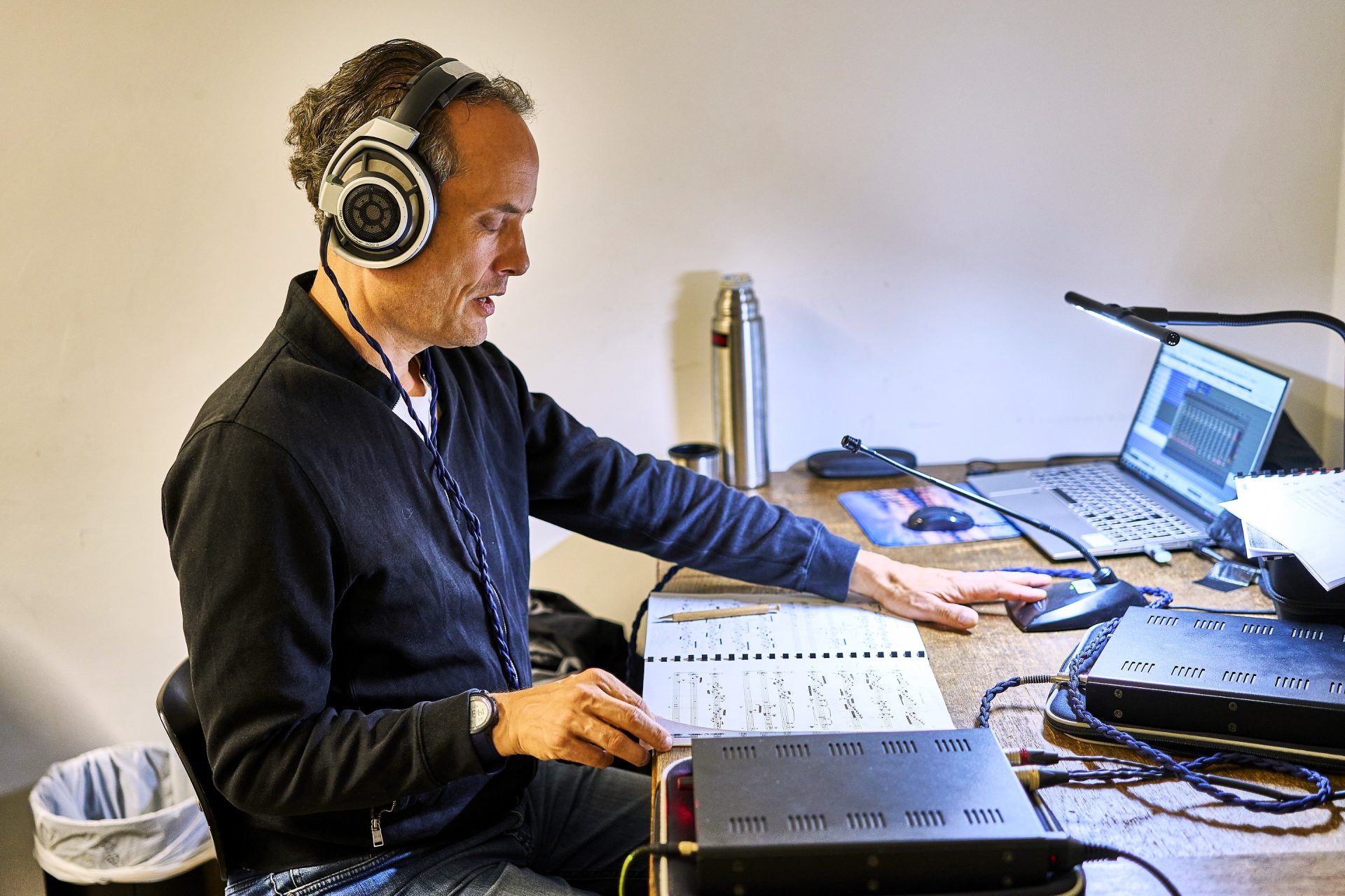 Cybele Studio on the road – Ingo Schmidt-Lucas during a production of ensemble works by Jean-Pierre Leguay (Hochschule für Musik und Darstellende Kunst Stuttgart); wearing Sennheiser HD800 headphones on location, with two Headphone Optimizer Pro units for headphone equalisation, a score and a laptop in front of him
