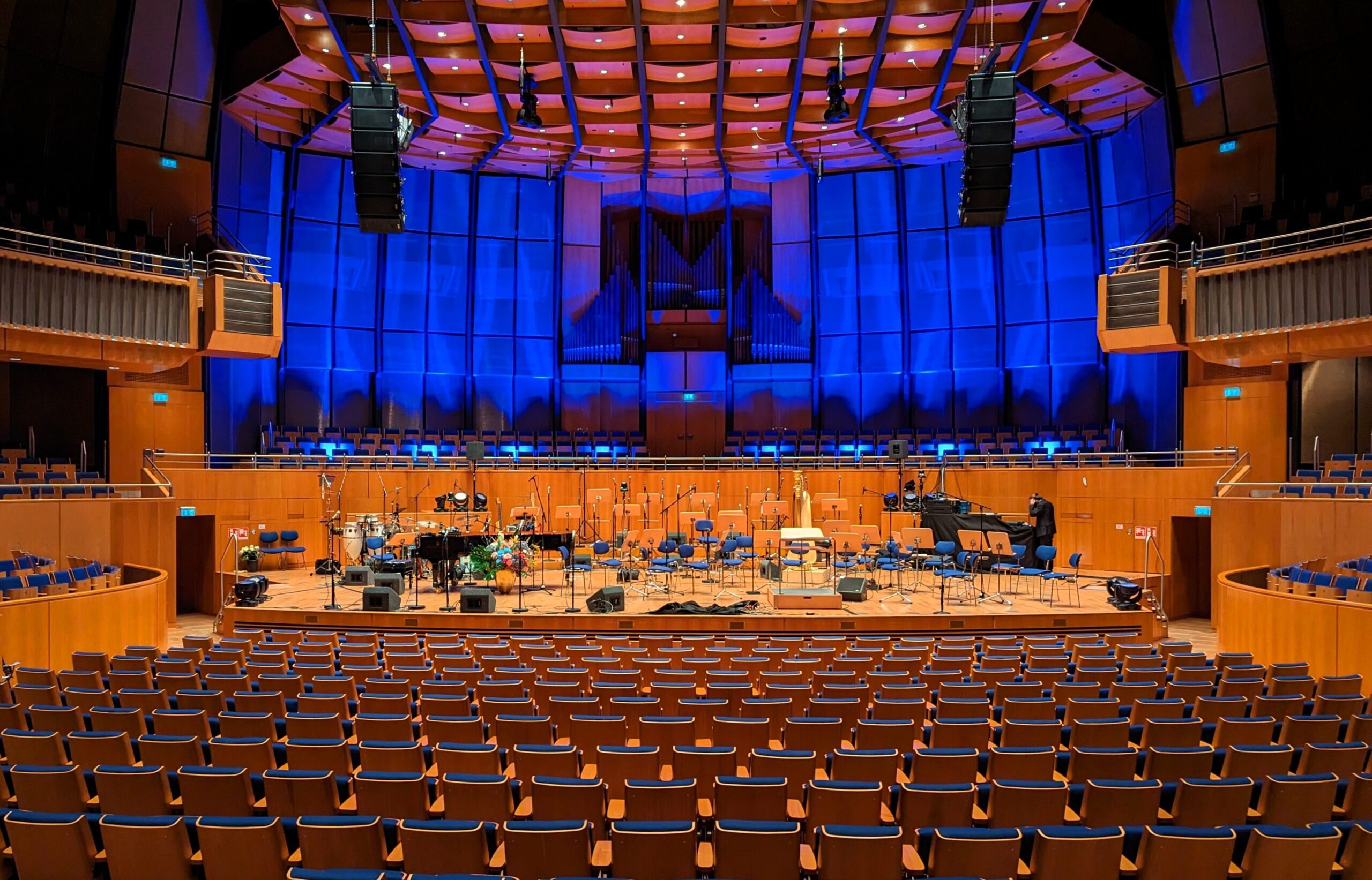 Cybele Studio on the road – 64-channel live production with sound reinforcement: a view from the balcony across the empty hall towards the miked stage, with the blue-lit organ case behind (Tonhalle Düsseldorf)